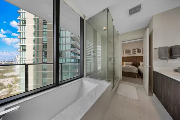 a en suite spacious bathroom with a tub shower and windows