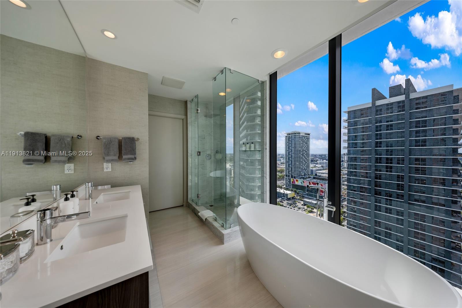 480 Northeast 31st Street, Unit 2807 Miami, FL 33137 - Photo 26 of 45 a bathroom with a bathtub a double vanity sink and mirror