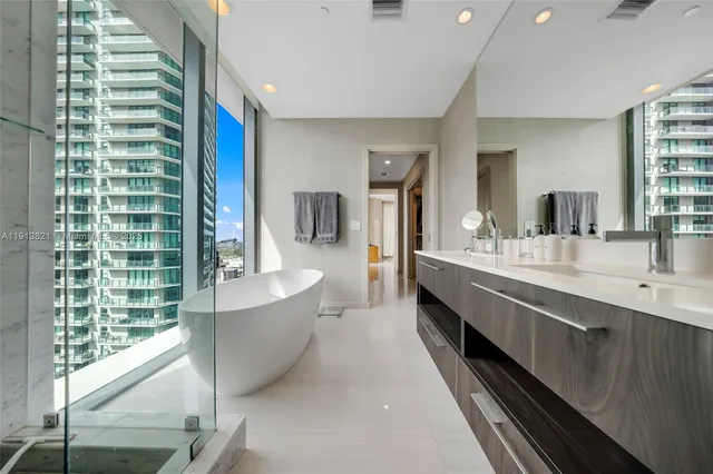 a en suite bathroom with a double vanity sink a mirror and a bathtub