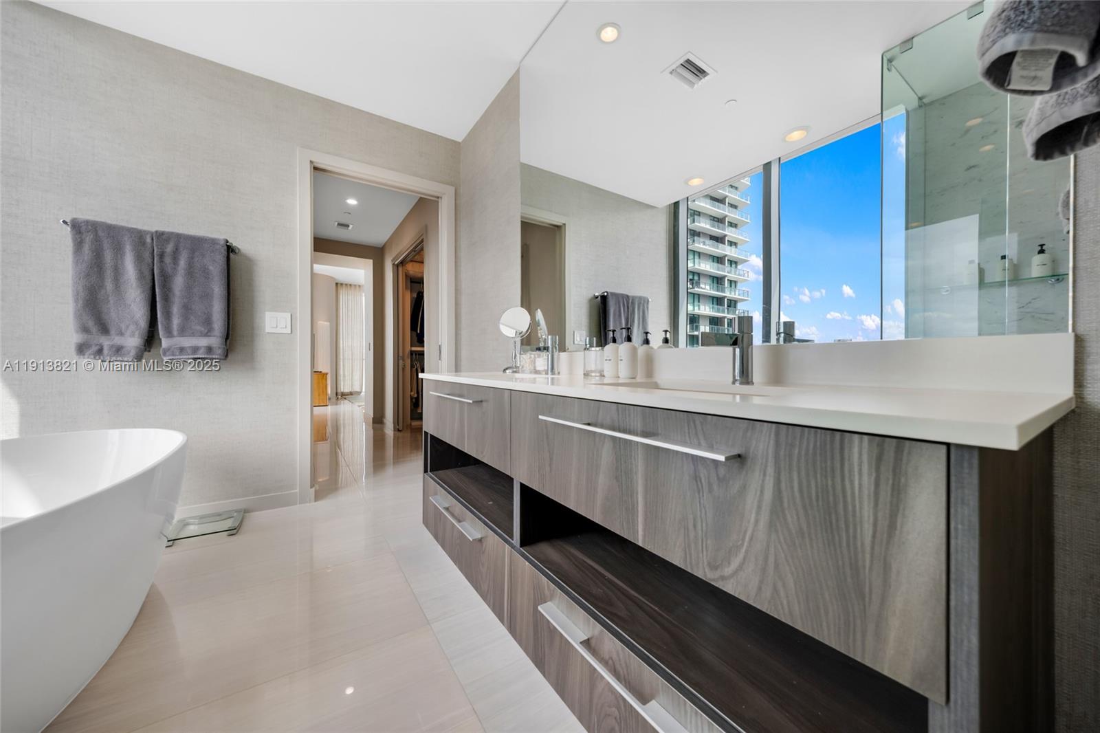 480 Northeast 31st Street, Unit 2807 Miami, FL 33137 - Photo 29 of 45 a en suite bathroom with a double vanity sink a mirror and a bathtub