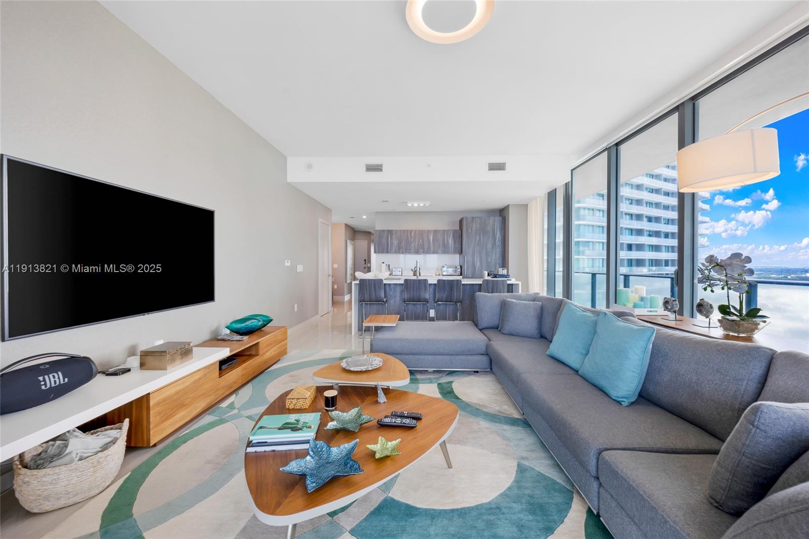 480 Northeast 31st Street, Unit 2807 Miami, FL 33137 - Photo 5 of 45 a living room with furniture and a flat screen tv