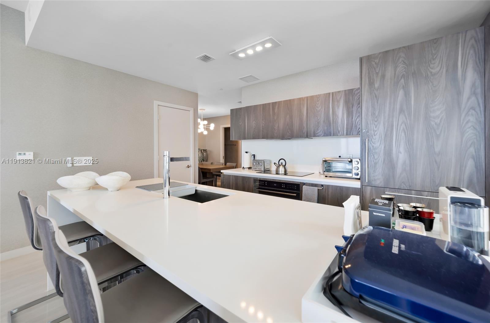 480 Northeast 31st Street, Unit 2807 Miami, FL 33137 - Photo 8 of 45 a kitchen with kitchen island a stove a table and chairs