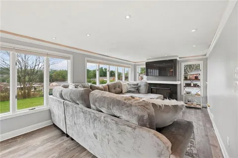 a living room with furniture large window and a fireplace