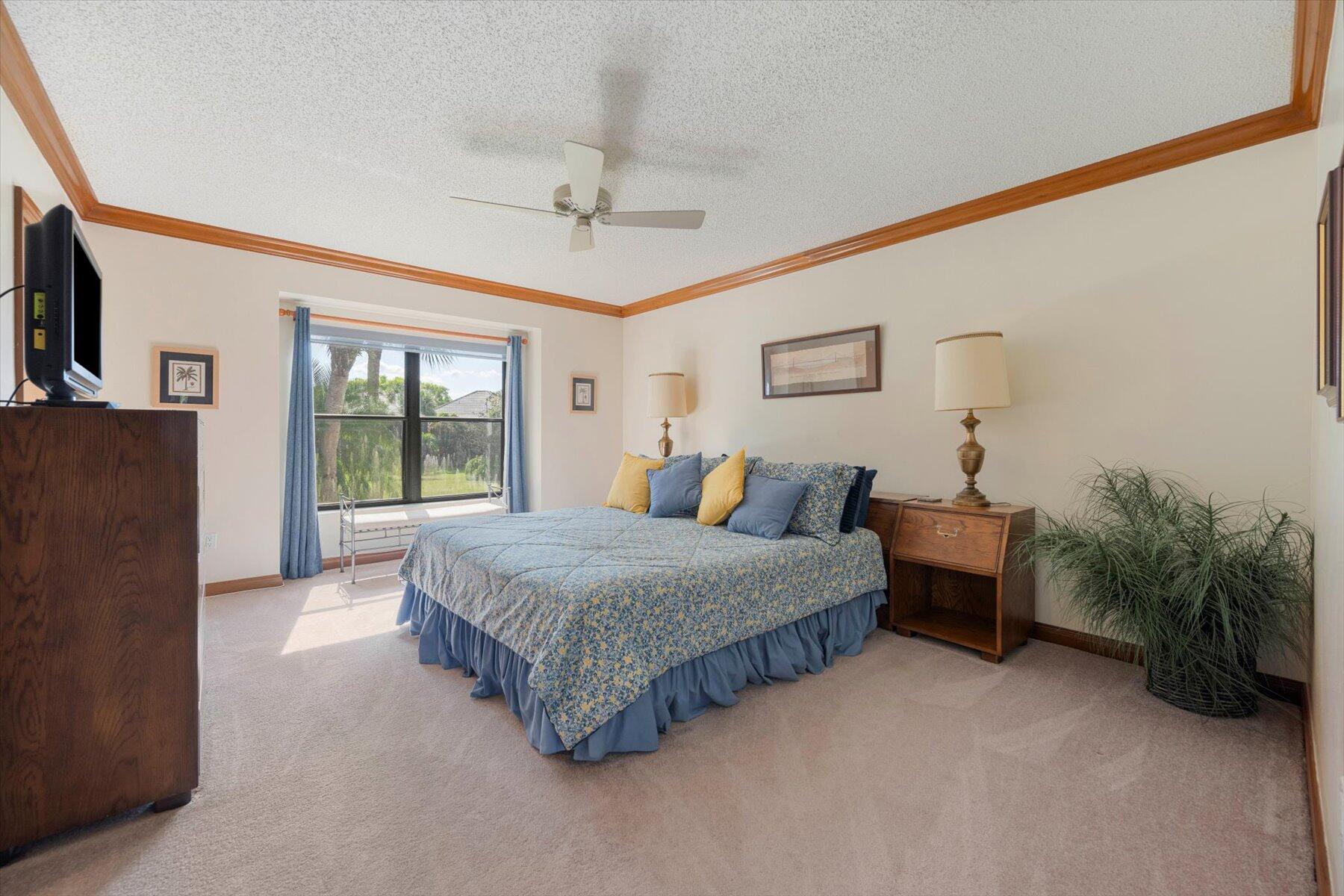 13244 Polo Club Road, Unit C207 Wellington, FL 33414 - Photo 12 of 31 a spacious bedroom with a bed table and a flat screen tv