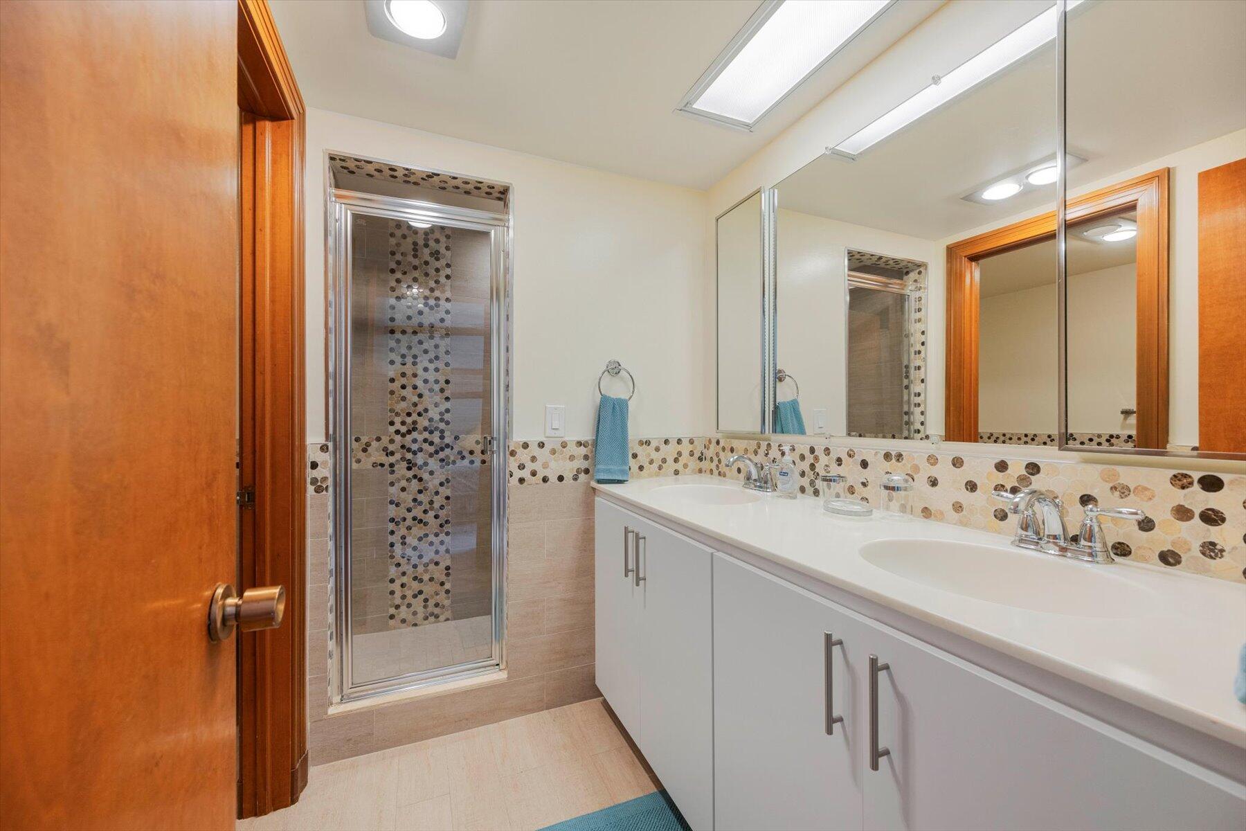 13244 Polo Club Road, Unit C207 Wellington, FL 33414 - Photo 14 of 31 a bathroom with a shower sink and mirror