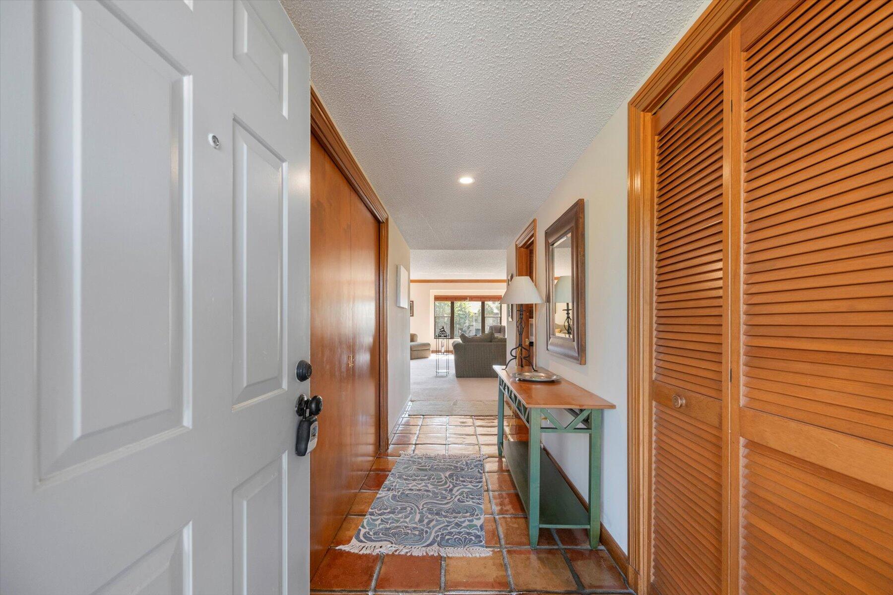 13244 Polo Club Road, Unit C207 Wellington, FL 33414 - Photo 24 of 31 a hallway with a dinning table and chairs