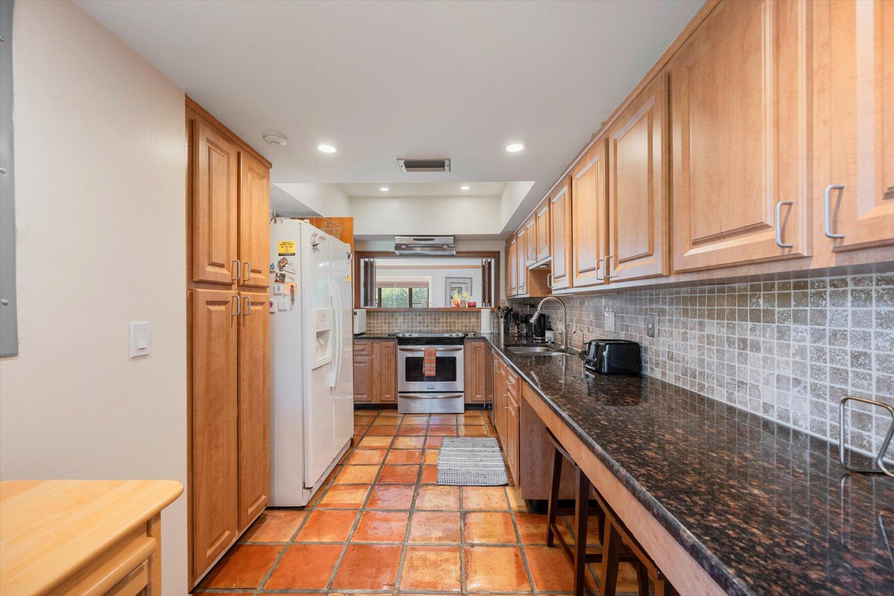 13244 Polo Club Road, Unit C207 Wellington, FL 33414 - Photo 5 of 31 a kitchen with stainless steel appliances granite countertop a refrigerator and a stove top oven