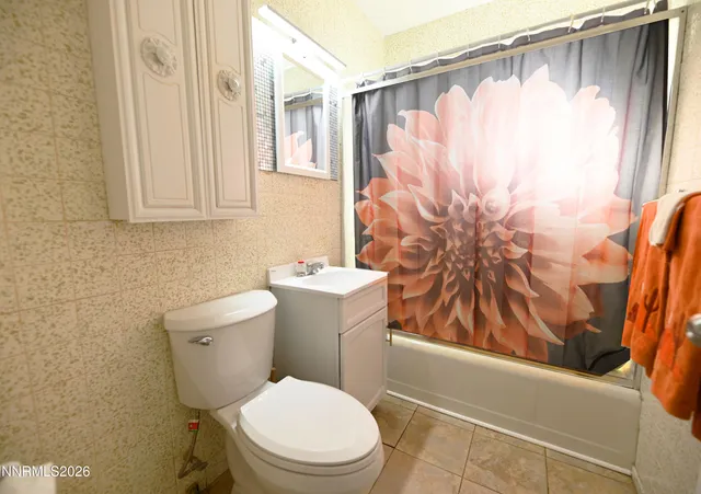a white toilet sitting next to a shower curtain
