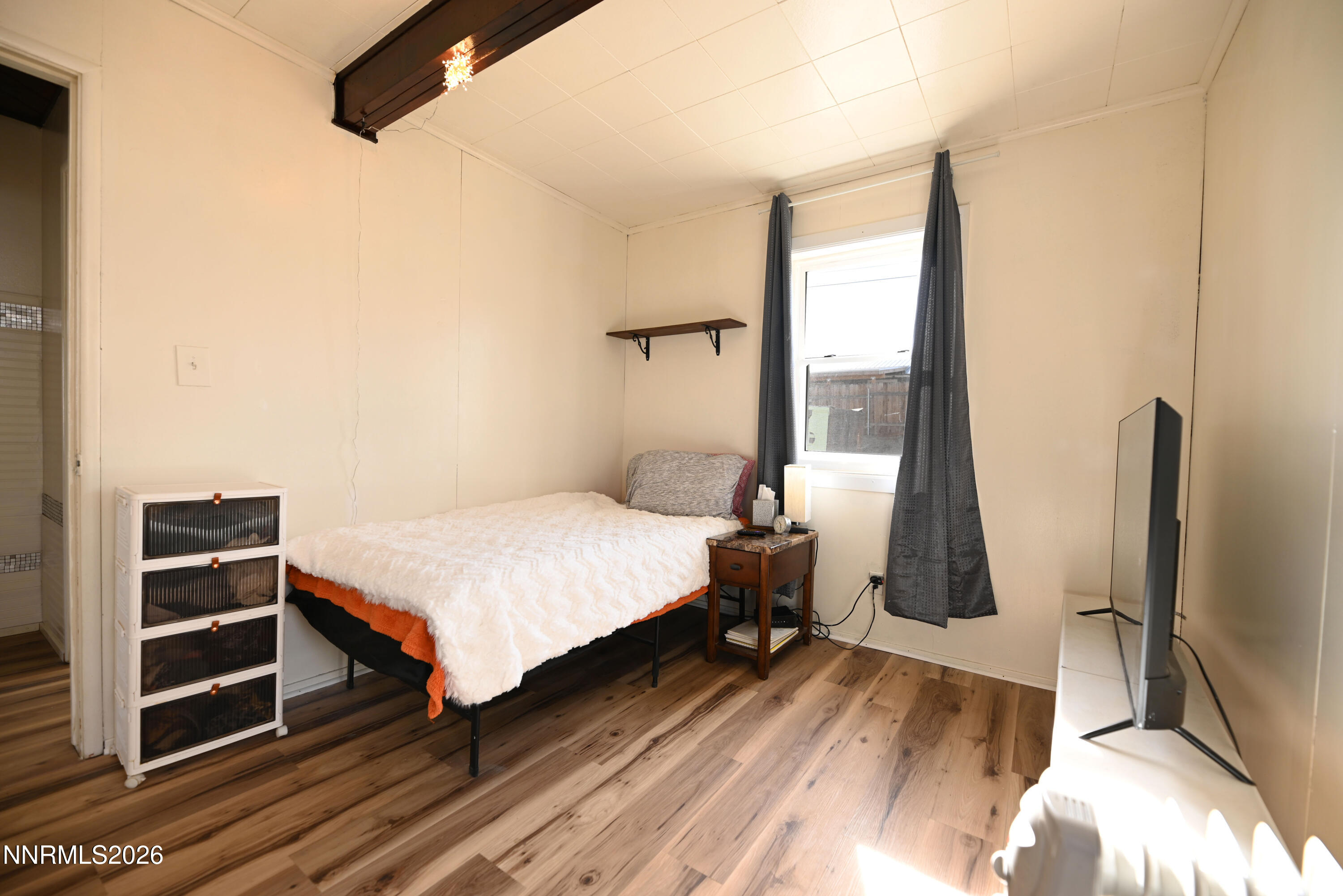 110 Harrison Street Hawthorne, NV 89415 - Photo 20 of 30 a bedroom with a bed and a flat tv screen on a dresser