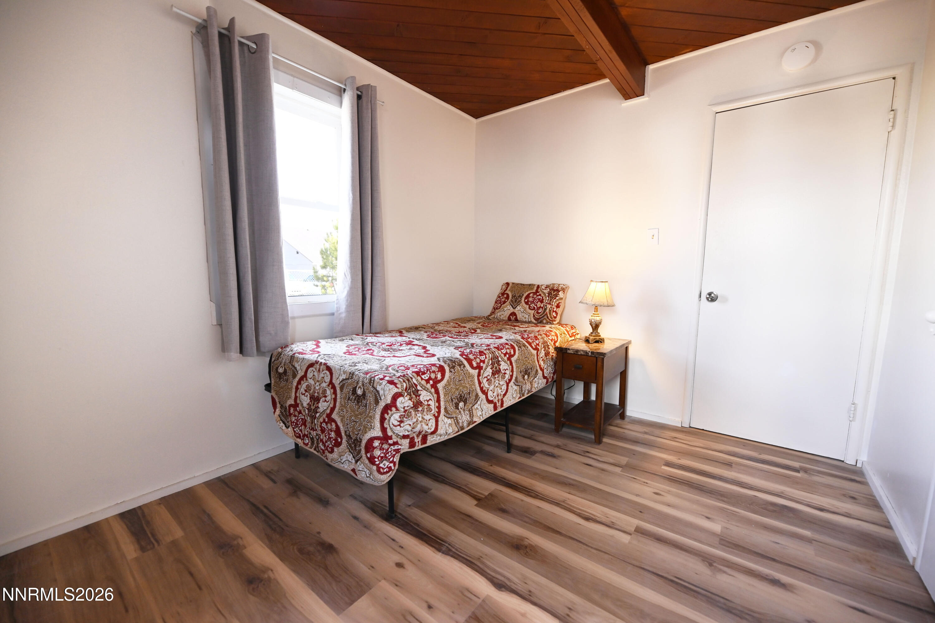 110 Harrison Street Hawthorne, NV 89415 - Photo 22 of 30 a bedroom with a bed and wooden floor