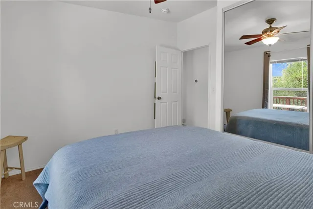 a view of a bedroom with a ceiling fan and a rug