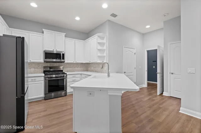 a kitchen with a sink stainless steel appliances and cabinets