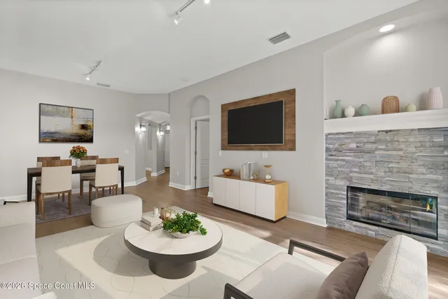 a living room with furniture a fireplace and a flat screen tv