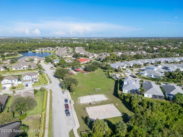 an aerial view of a house with swimming pool a yard and lake view