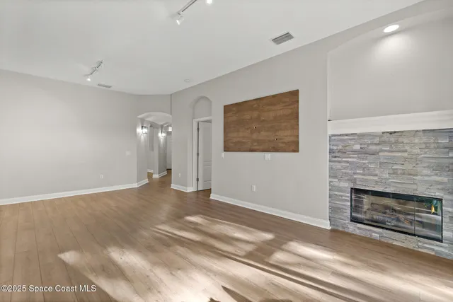 a view of empty room with wooden floor and fireplace