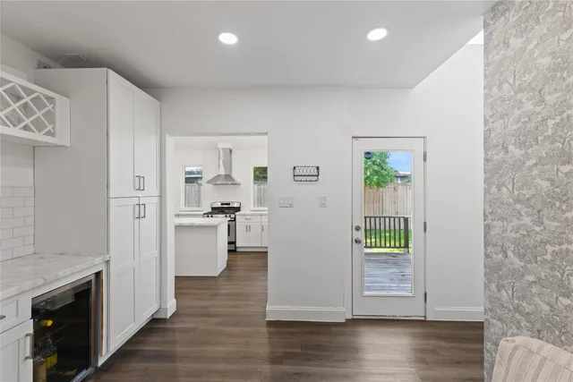 a view of a kitchen with refrigerator and wooden floor