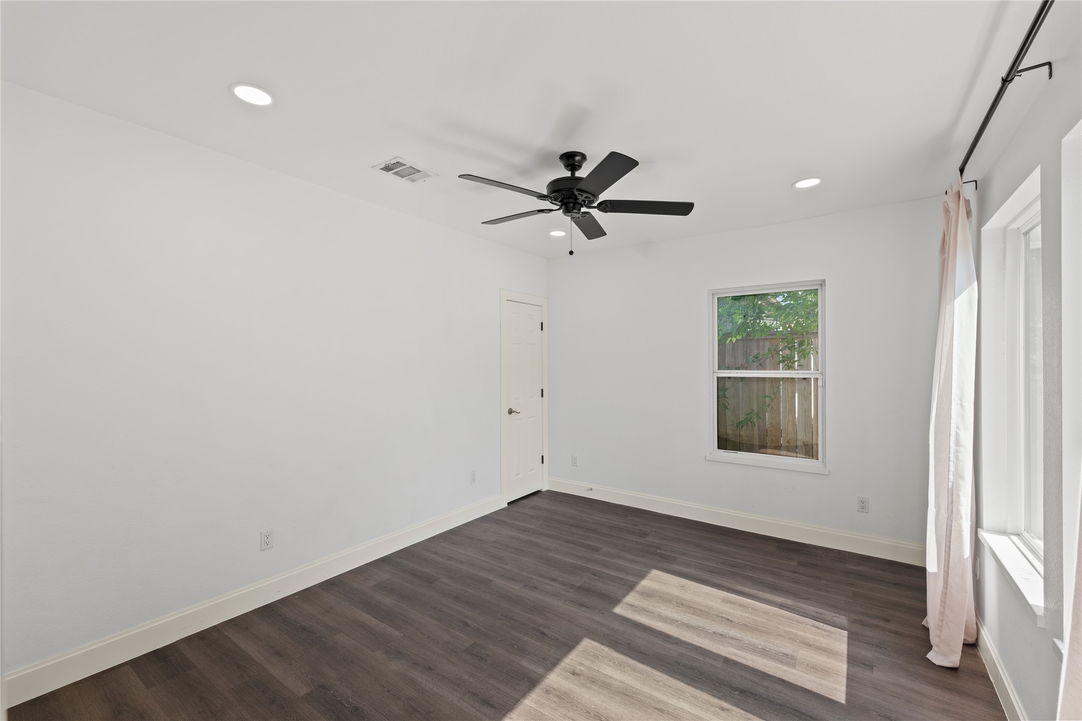 3211 Cochran Street Houston, TX 77009 - Photo 18 of 32 an empty room with a window and a ceiling fan