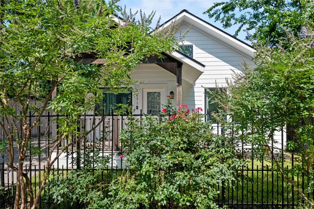 a small yard with a white roof and potted plants
