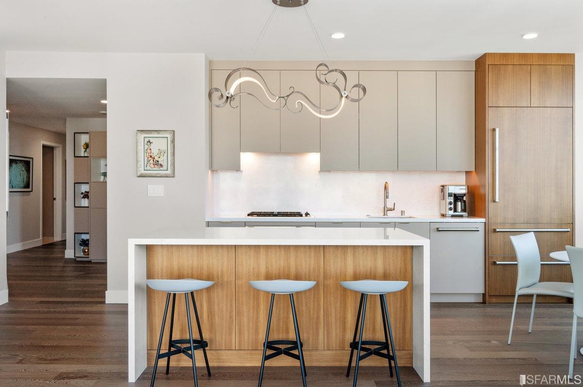 338 Spear Street, Unit 39E San Francisco, CA 94105 - Photo 24 of 97 a kitchen with stainless steel appliances granite countertop a table chairs in it and wooden floors