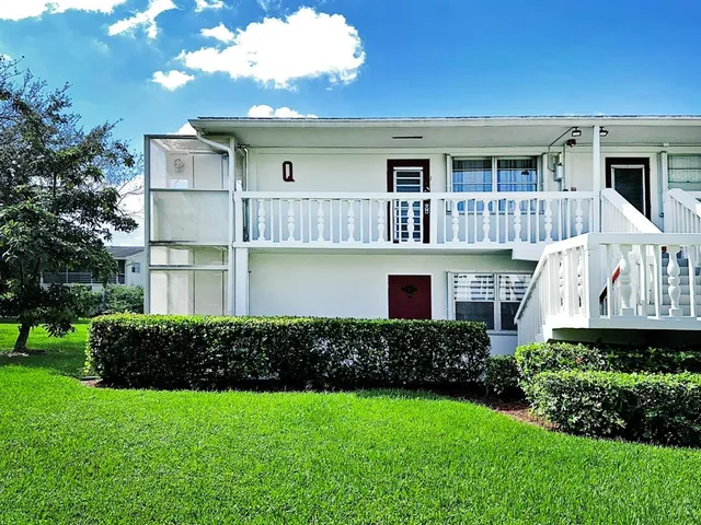 a front view of a house with a yard and potted plants