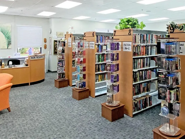 a front view of a multi story residential apartment building with yard and outdoor seating
