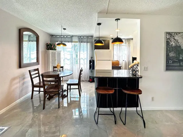 a dining room with a table chairs and a kitchen view