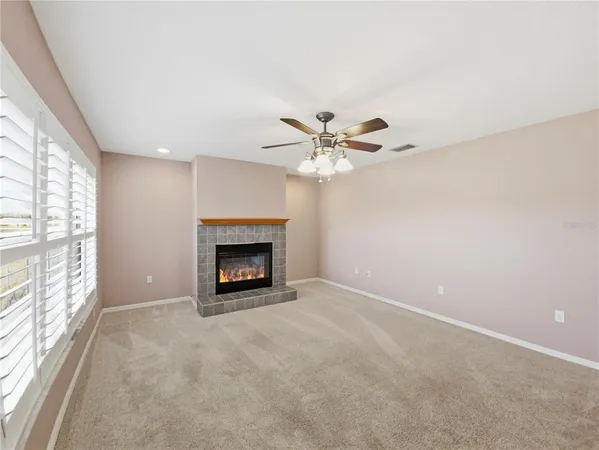 a view of an empty room with a fireplace and a window