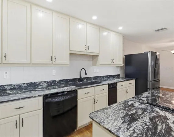 a kitchen with stainless steel appliances granite countertop a stove a sink and a refrigerator