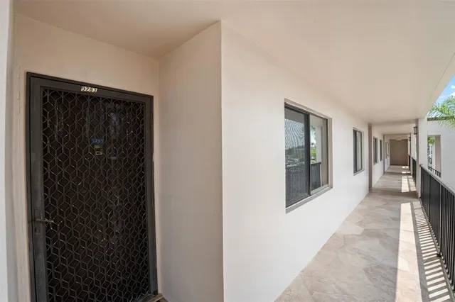 a hallway with wooden floor windows and a living room