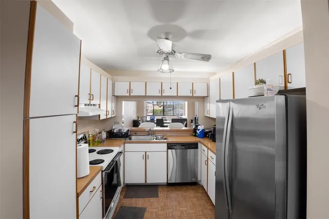 a kitchen with stainless steel appliances a refrigerator sink and cabinets