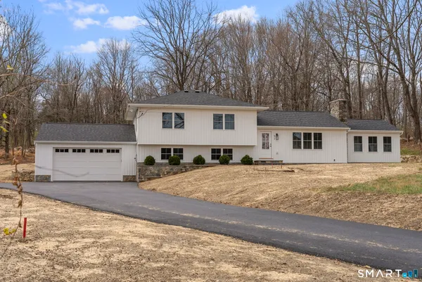a front view of a house with yard and trees
