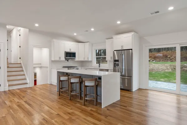 a kitchen with stainless steel appliances kitchen island granite countertop a refrigerator and a stove top oven