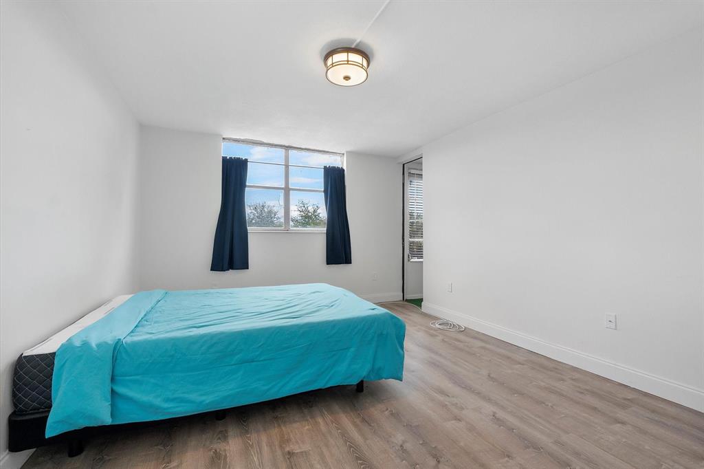 2840 Somerset Drive, Unit 205M Lauderdale Lakes, FL 33311 - Photo 13 of 22 a bedroom with a bed and a window