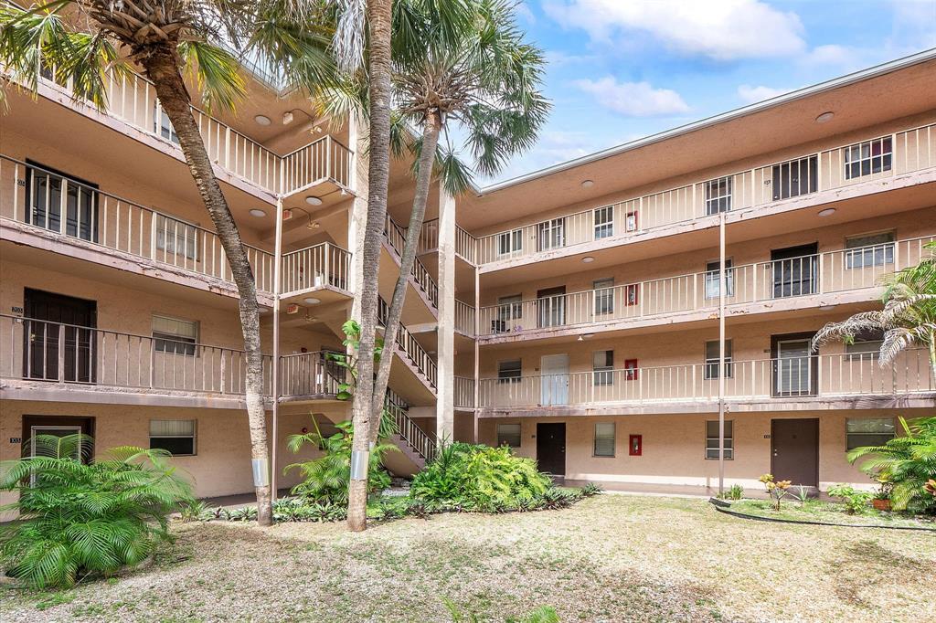 2840 Somerset Drive, Unit 205M Lauderdale Lakes, FL 33311 - Photo 2 of 22 a front view of a building with a garden