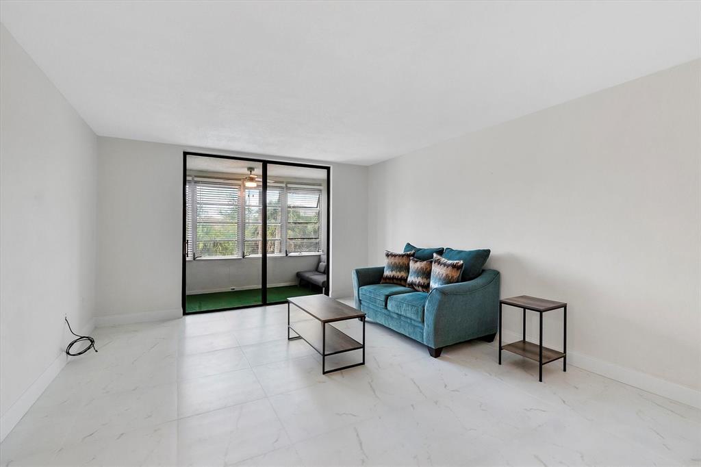 2840 Somerset Drive, Unit 205M Lauderdale Lakes, FL 33311 - Photo 5 of 22 a living room with furniture and large windows