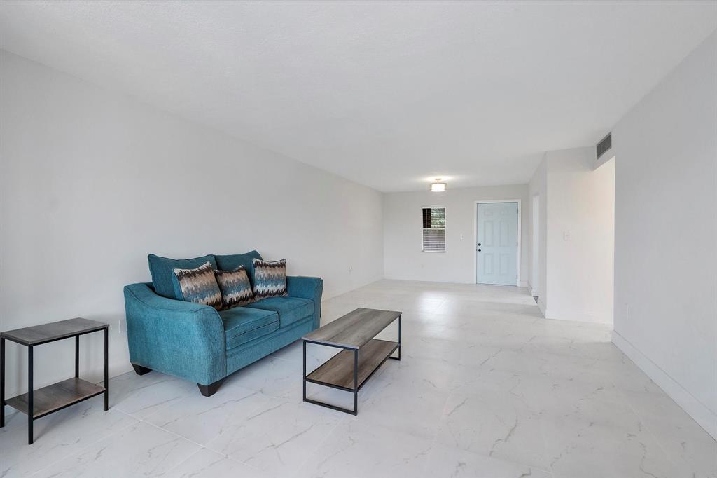 2840 Somerset Drive, Unit 205M Lauderdale Lakes, FL 33311 - Photo 7 of 22 a living room with furniture and a couch