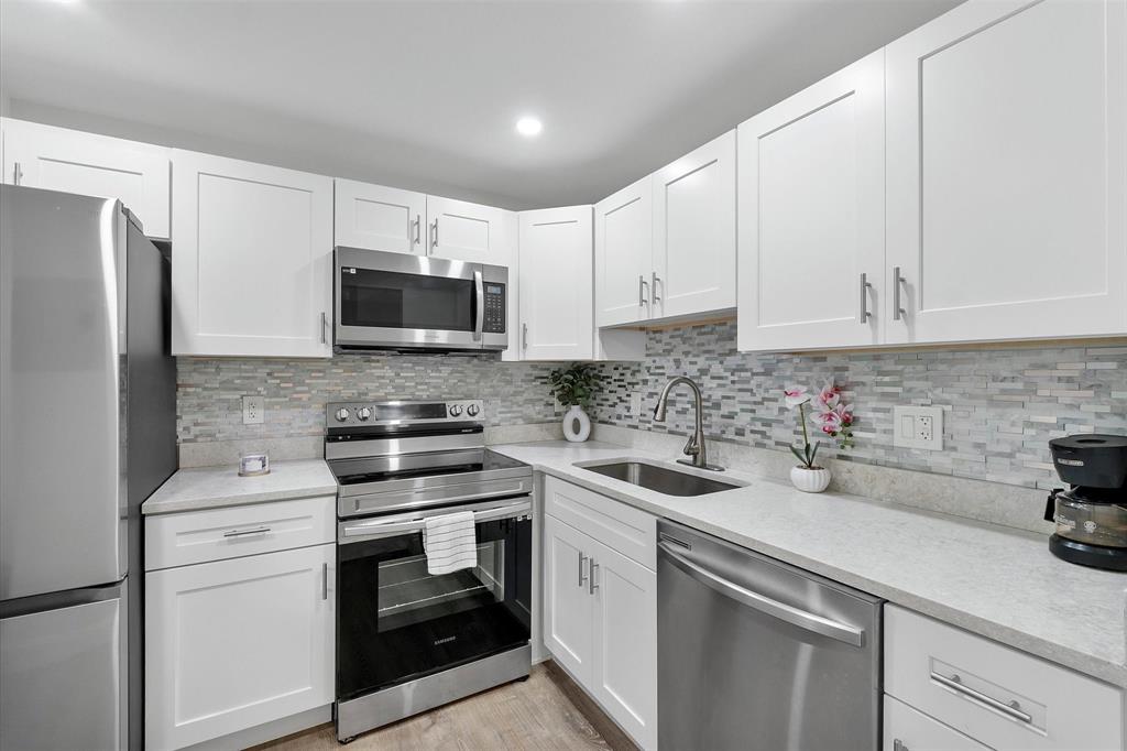 2840 Somerset Drive, Unit 205M Lauderdale Lakes, FL 33311 - Photo 10 of 22 a kitchen with white cabinets and stainless steel appliances