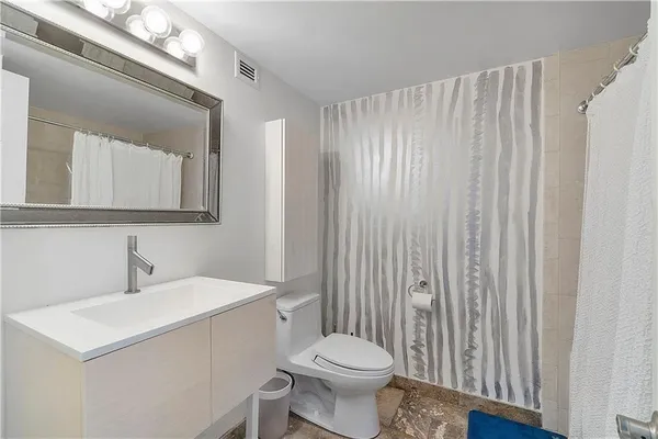 a bathroom with a sink a toilet and shower