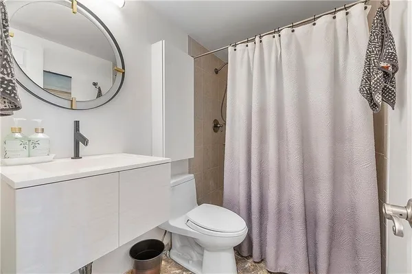 a bathroom with a sink a toilet and a mirror