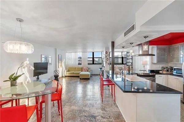 a living room with furniture kitchen view and a chandelier