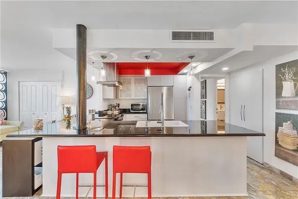 a kitchen with stainless steel appliances kitchen island granite countertop a table and chairs in it