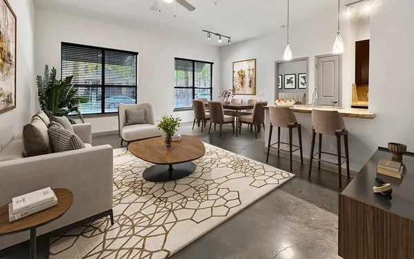 a living room with furniture a large window and a dining table