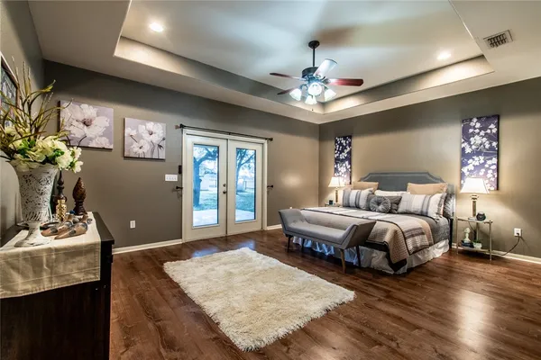 a spacious bedroom with a bed dresser and a window