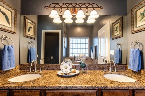 a bathroom with a granite countertop double vanity sinks and a mirror