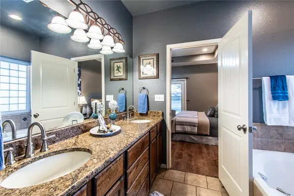 a bathroom with a granite countertop sink a large mirror and shower