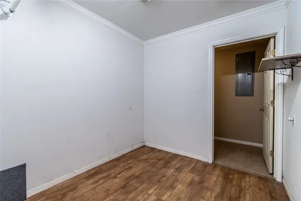 a view of empty room with wooden floor and closet