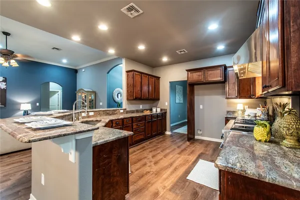 a kitchen with stainless steel appliances granite countertop a sink stove and refrigerator