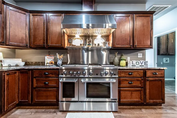 a kitchen with stainless steel appliances granite countertop a stove and a microwave