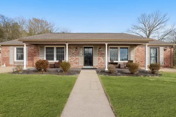 a front view of a house with a yard and potted plants