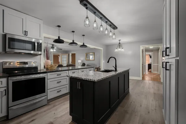 a kitchen with granite countertop a sink and stainless steel appliances